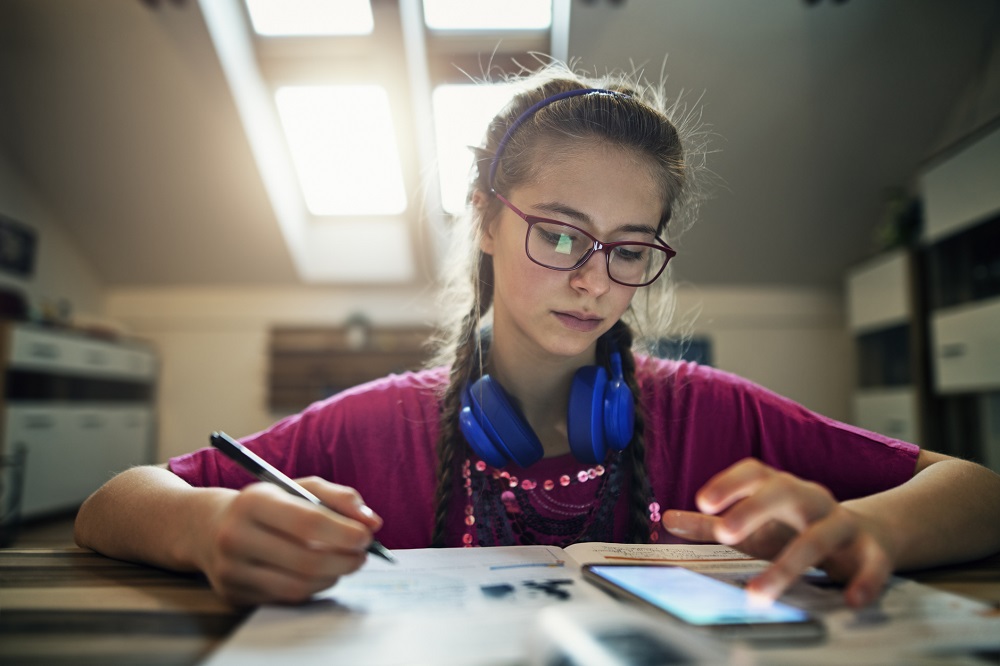 Teen girl revising for exams in her bedroom