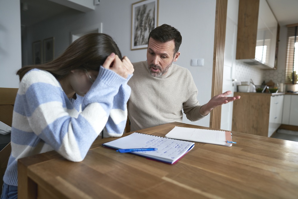 Dad encouraging teen daughter over her school work