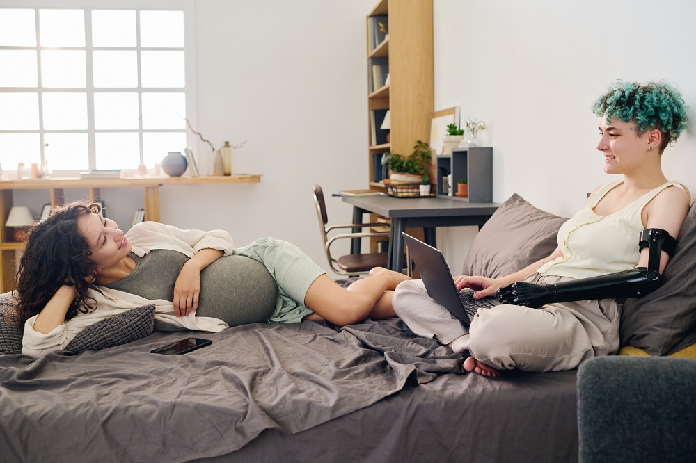 Pregnant mum and partner chatting in their bedroom