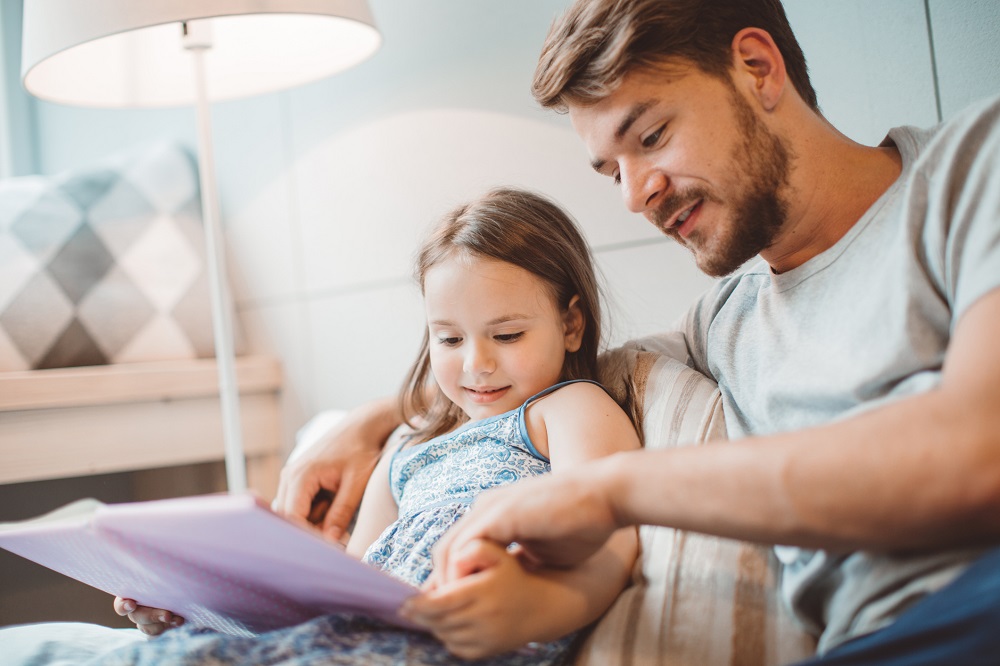 Young girl reading with her dad
