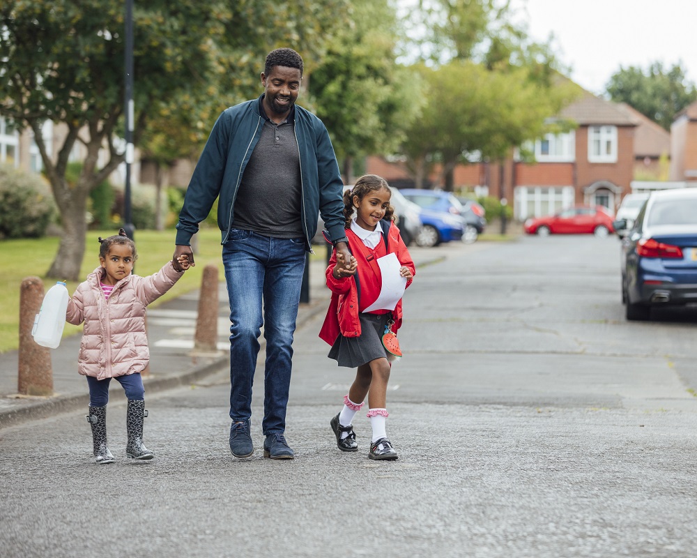 Dad taking older and younger child to school