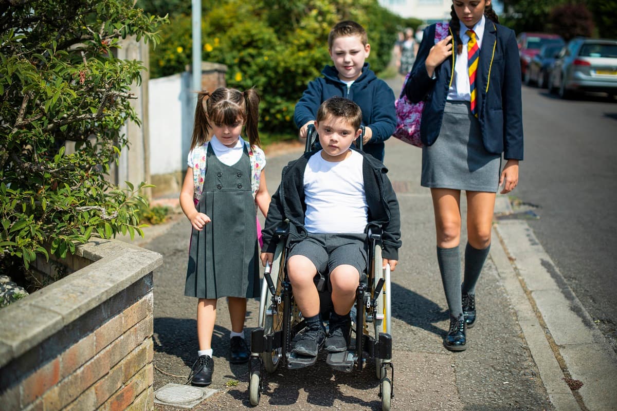 Children walking and wheeling to school on a sunny day.