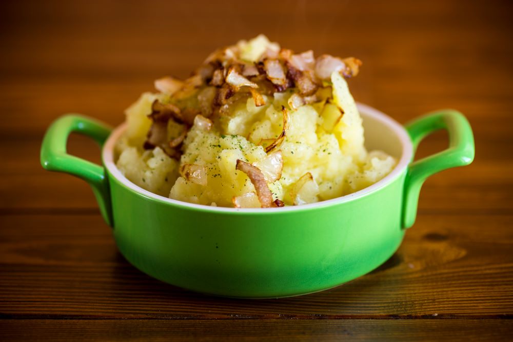 Stovies in a green casserole dish.