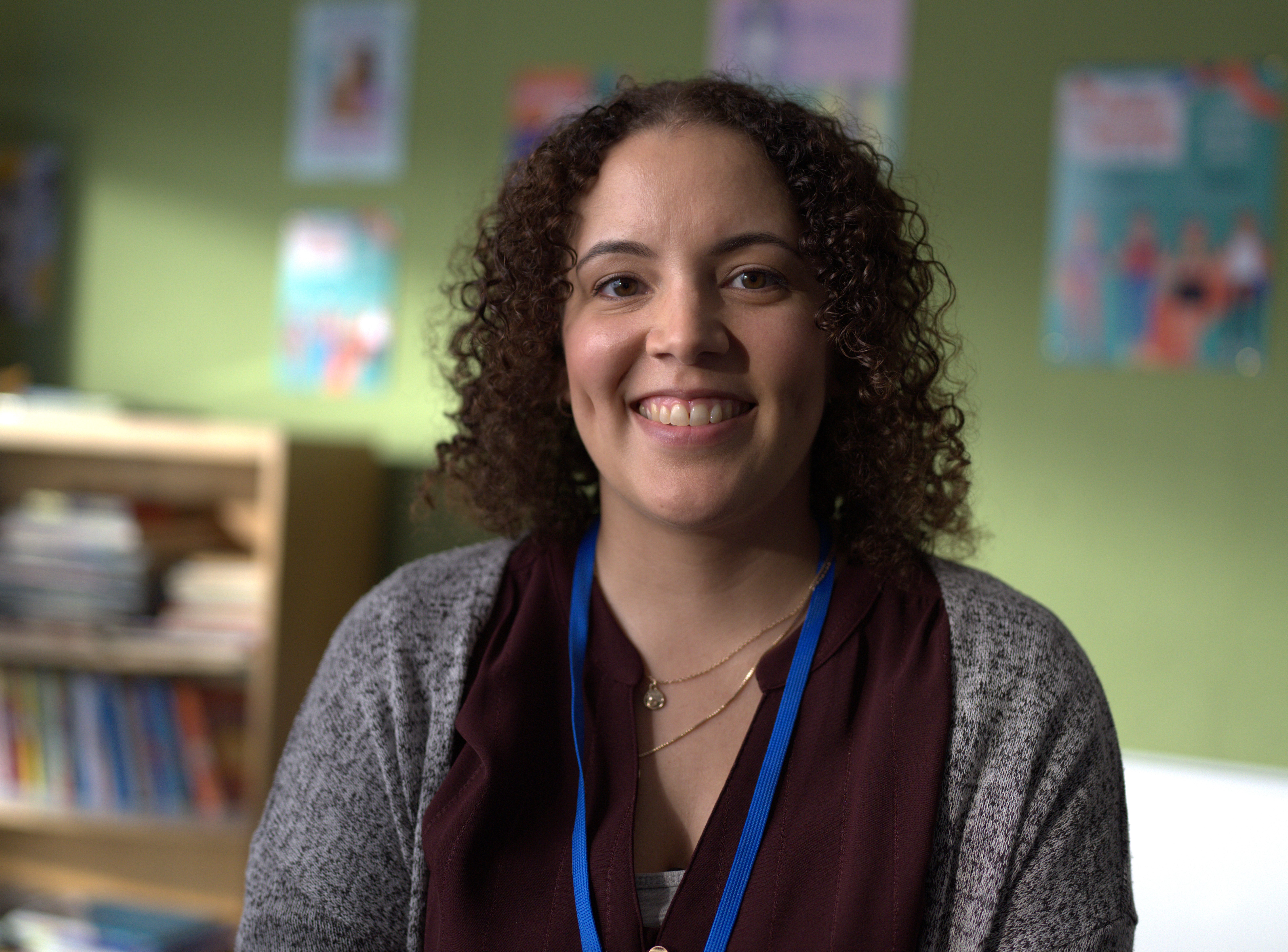 Teacher in a classroom, smiling.