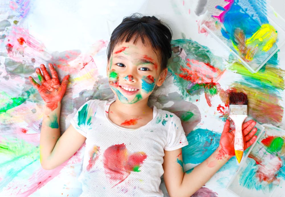 Smiling child covered in paint.