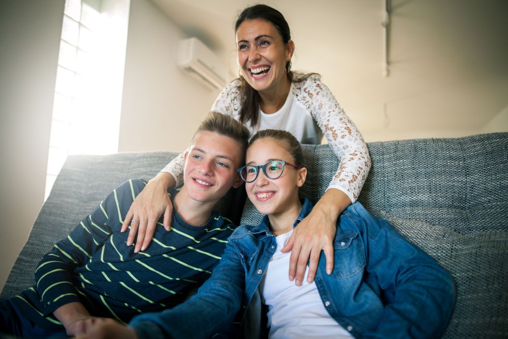 Mother with teen son and daughter, all smiling,