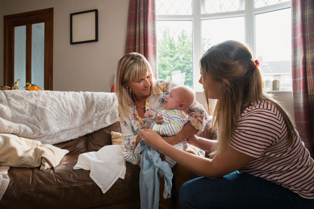 Health visitor visiting a mother and baby at home.