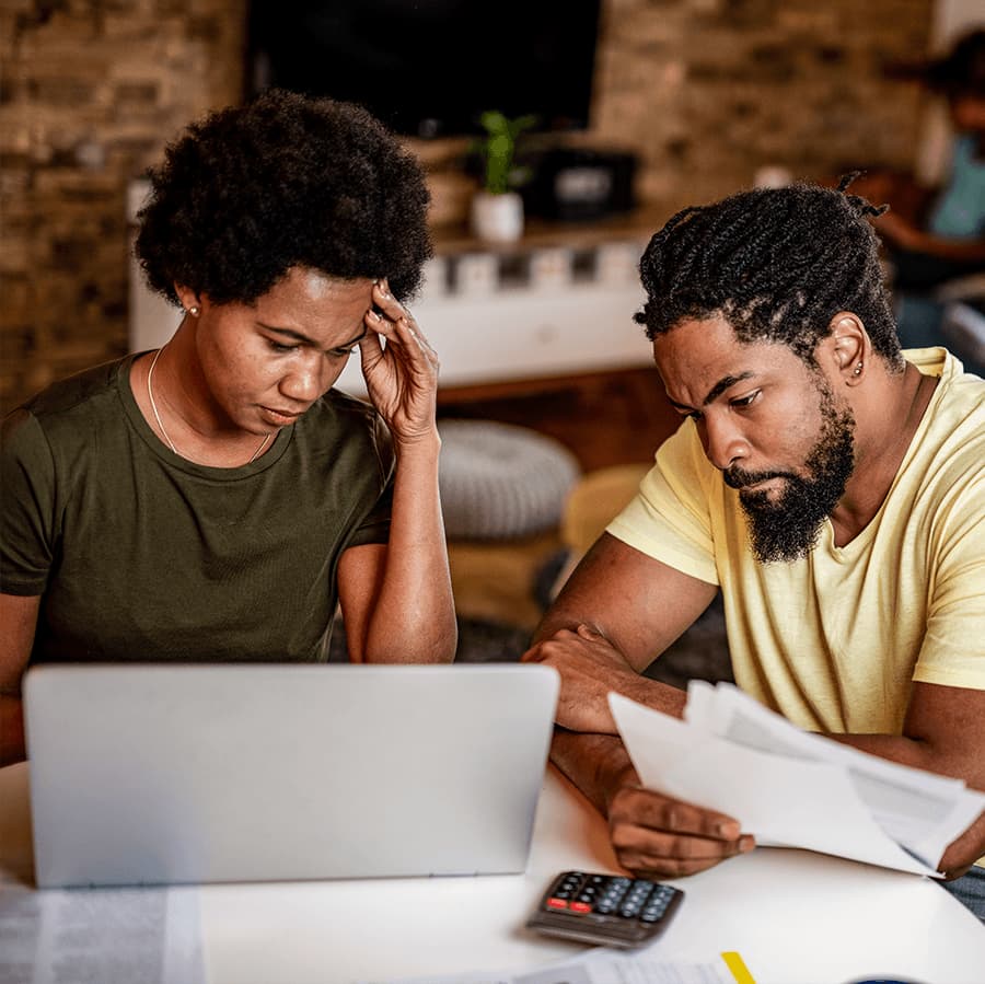 Couple looking at bills and laptop