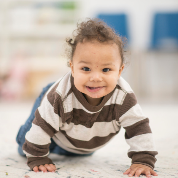 Photo of a baby crawling and smiling 