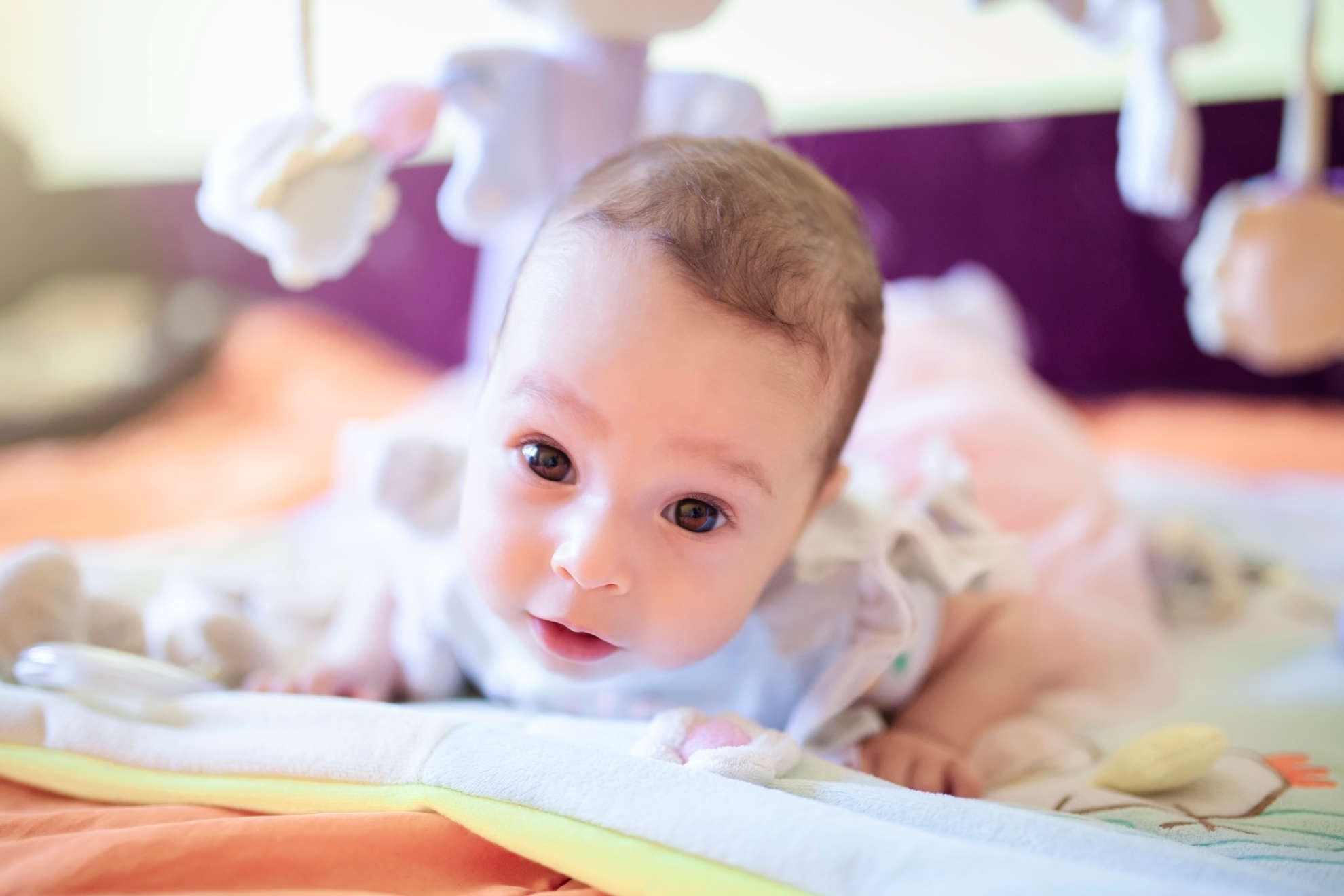 Photo of a baby lying on their tummy on a play matt 