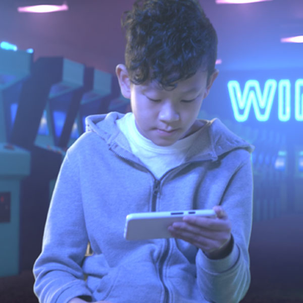 boy-looking-at-phone-in-arcade