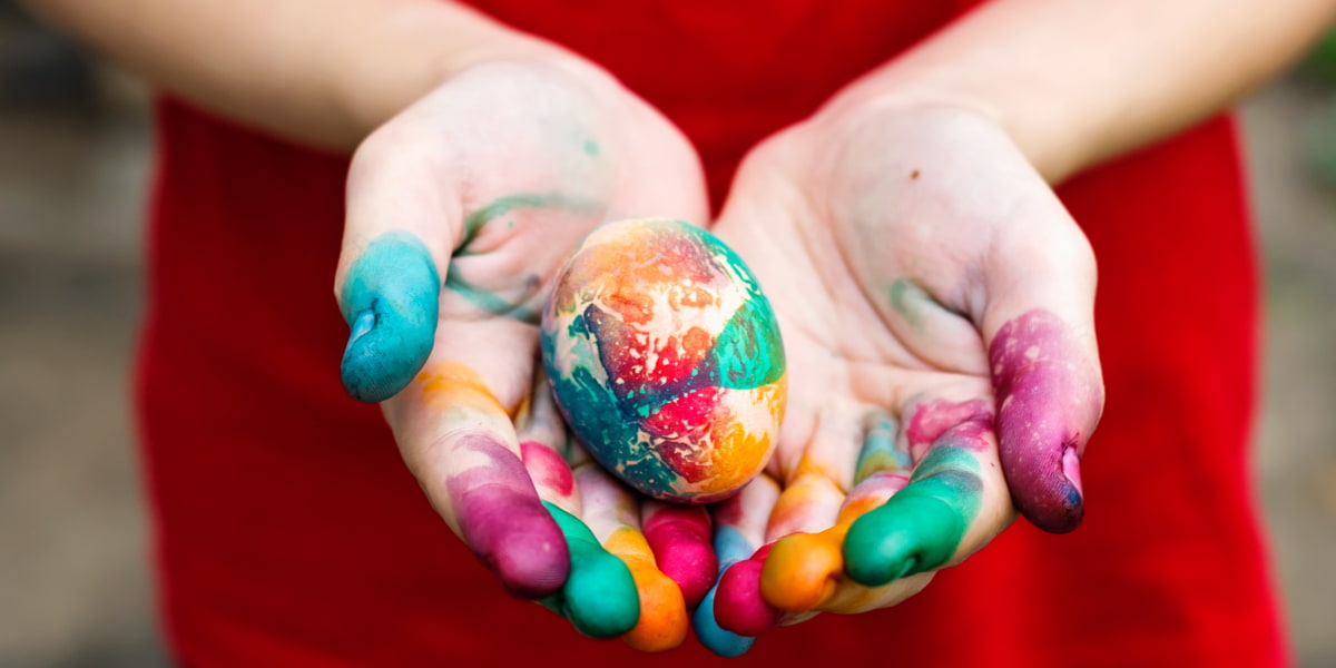 Child holding painted Easter egg