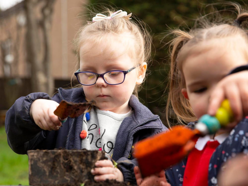 Image of a child playing with mud outdoors.