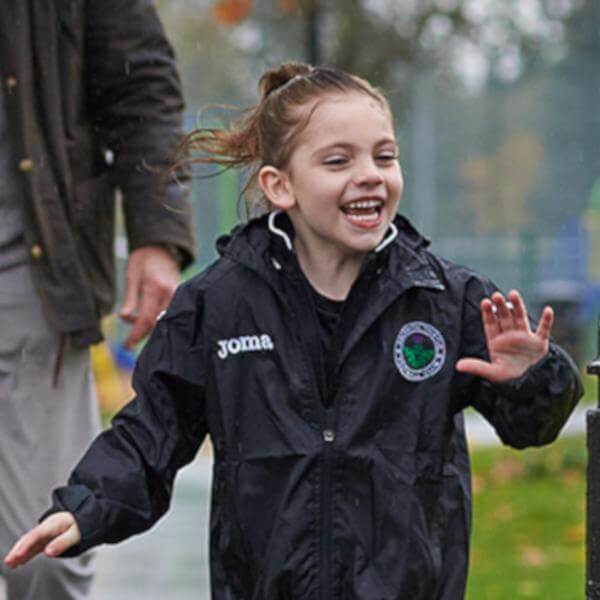 Photo of a child running through the rain the the park 