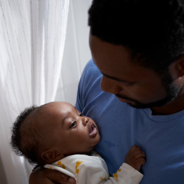 Image of a dad looking at the baby in his arms.