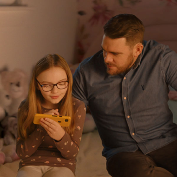 father-daughter-looking-at-phone-together-button