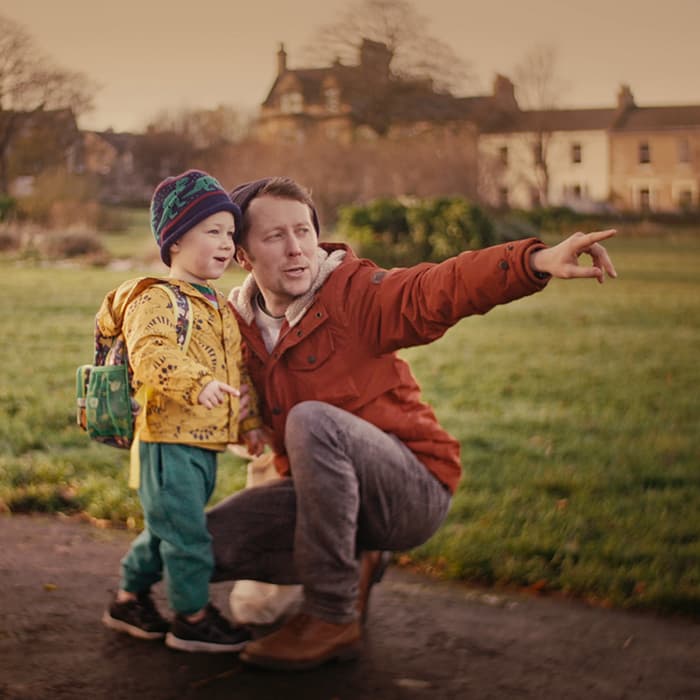 Father and son outdoors, the father is pointing at something