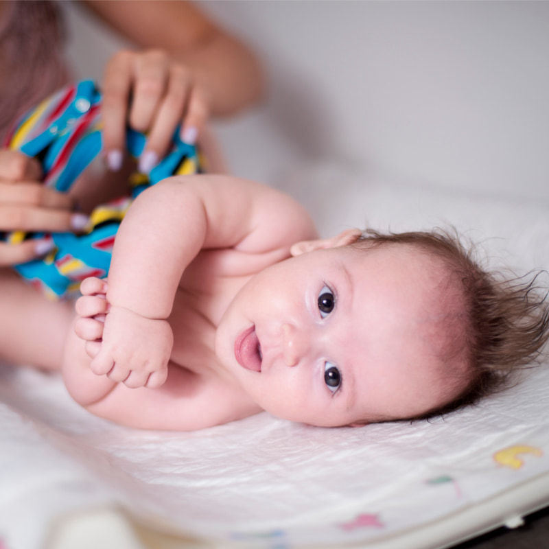 Image of a mum getting a baby dressed.