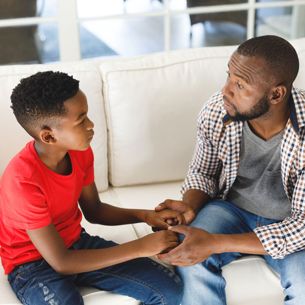 Father and son talking, holding hands