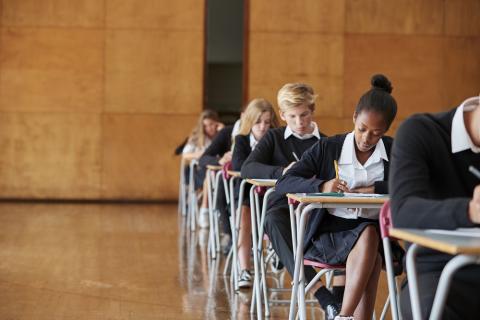 School students doing exams in a hall