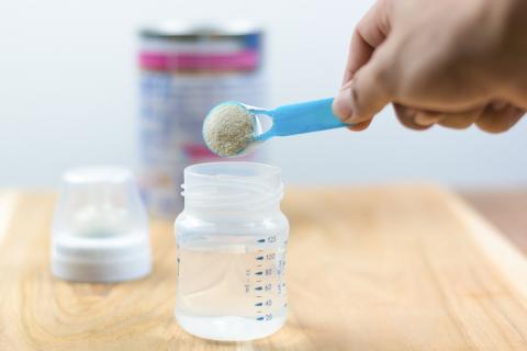 Parent measuring formula into a feeding bottle