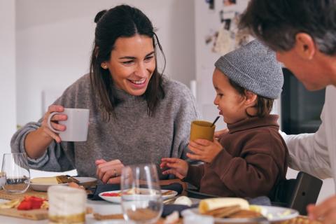 Mum, dad and young child eating breakfast together