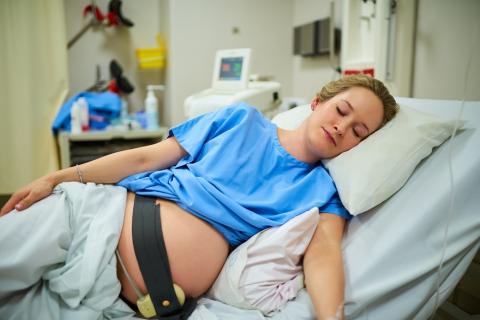 Pregnant woman in hospital lying on her side