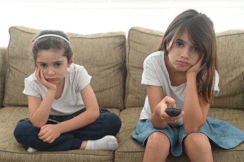 Girls sitting on the sofa looking bored