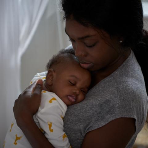 Photo of baby sleeping in its mothers arms