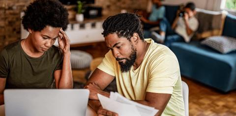 Couple looking at bills and laptop