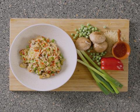 Bowl of sweet chilli vegetables and rice with ingredients