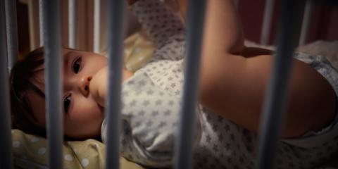 Photo of a baby awake in a cot