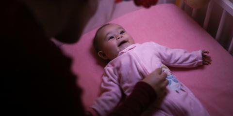 Photo of a baby awake and gazing at a mobile 