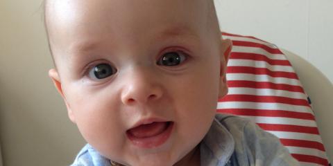 baby in highchair holding a potato