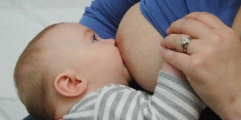 Photo of a baby suckling it mothers nipple