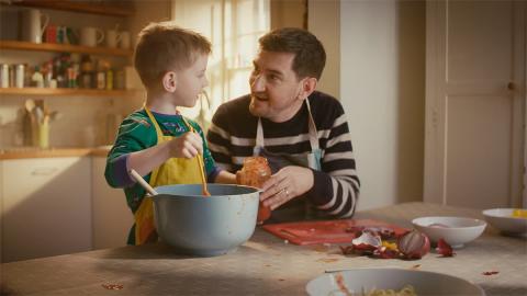 Father and son cooking together and chatting