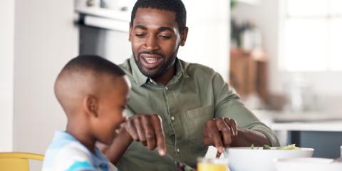 photo of a dad feeding son 