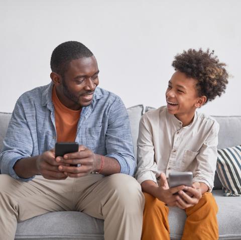 Dad and teen sitting on a sofa chatting to each other