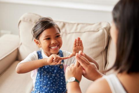 Mother and little girl talking using sign language