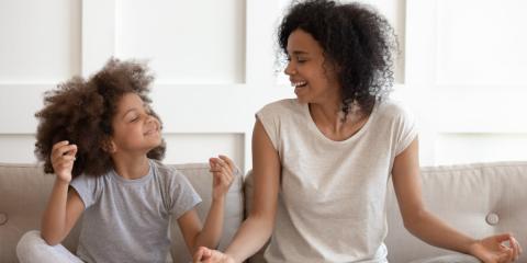 photo of a mum and a child cross legged on the couch laughing 