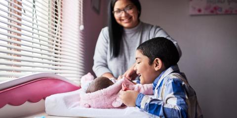 Mum and boy smiling at new baby