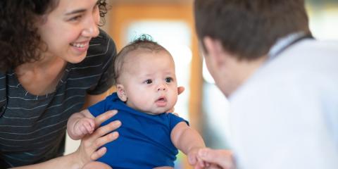 Photo of a mum holding a baby with other adult 