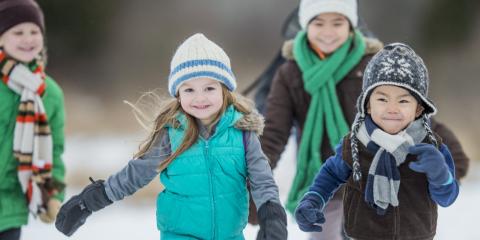 Children wrapped up in winter clothes running