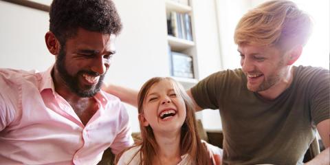 Same sex couple and girl laughing