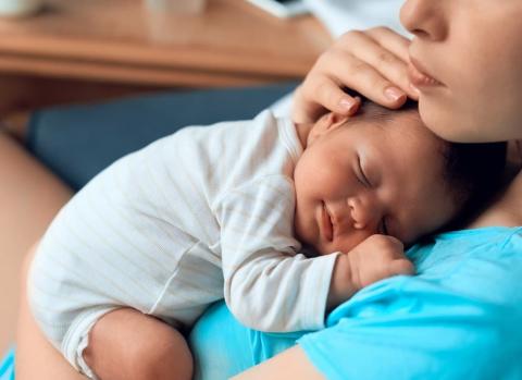 Mum holding sleeping baby