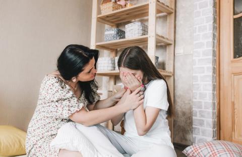 Mother comforting her teenage daughter, who looks upset