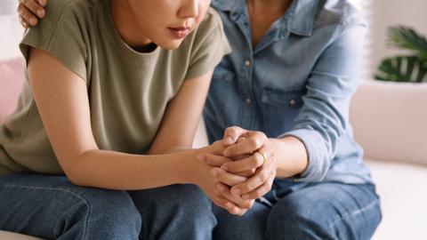 Teen girl and mum holding hands