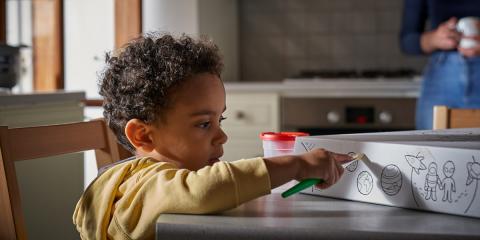 Photo of a toddler painting a baby box lid 