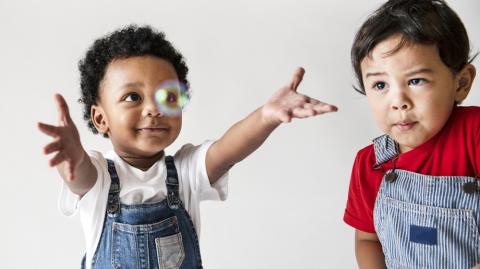 Two toddlers playing with bubbles