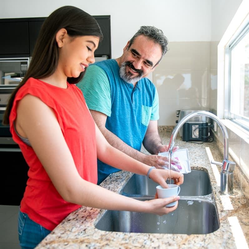 Father and daughter chatting while doing the washing up